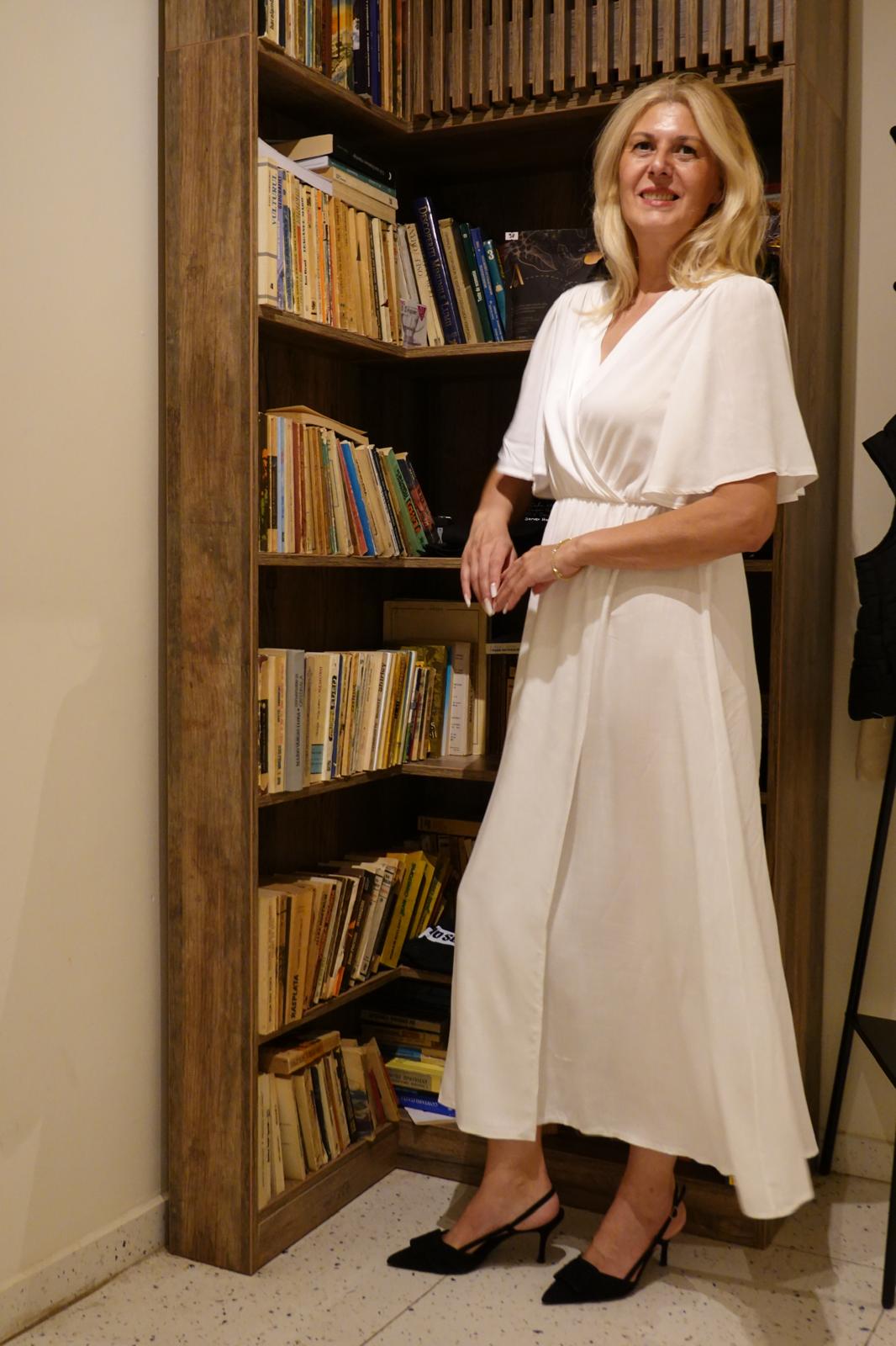 Elena Grisogono în fața unei biblioteci cu cărți de psihologie